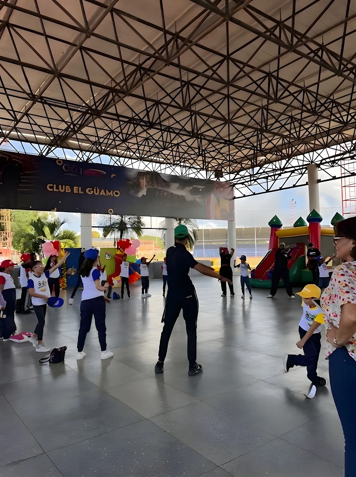 Un animador dirige a los niños en la cancha techada.